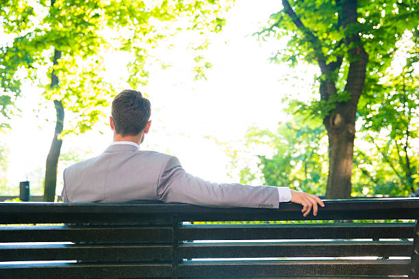 Many Things about Tomorrow: Finale Episode: The Transformative Vision 3 Liam sitting on a bench in a peaceful park, looking thoughtfully at a distance, reflecting on his journey and the enduring impact of his vision.