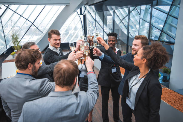 How to Manifest a Strong Business Spirit 3 A diverse team erupts in celebration with champagne toasts, high fives, and laughter in a modern office setting. This image captures the triumphant business spirit of a team achieving success through collaboration and perseverance.