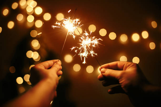 Beyond the Sparklers: Patriotic Poem 3 A close-up of hands holding sparklers, the vibrant sparks creating a trail of light against a dark background