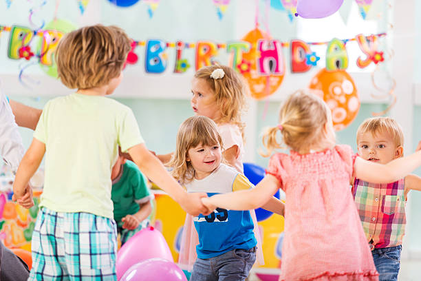 Children laugh and run as they play games at a birthday party