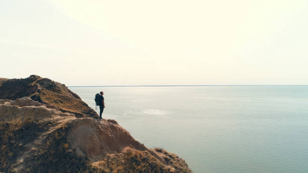 A Prisoner of Her Thoughts - Free Verse Poem - Person standing on a cliff overlooking the ocean
