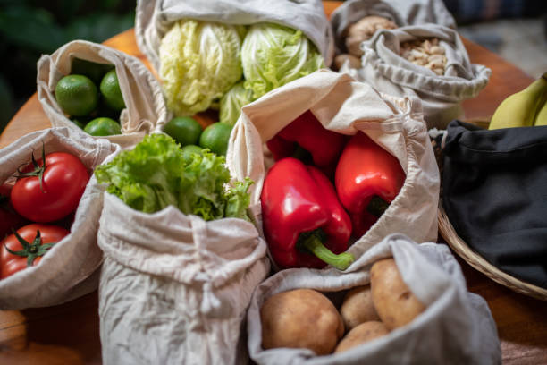 Reusable grocery bag filled with fresh, local produce, supporting local farmers and minimizing packaging waste for a sustainable future.