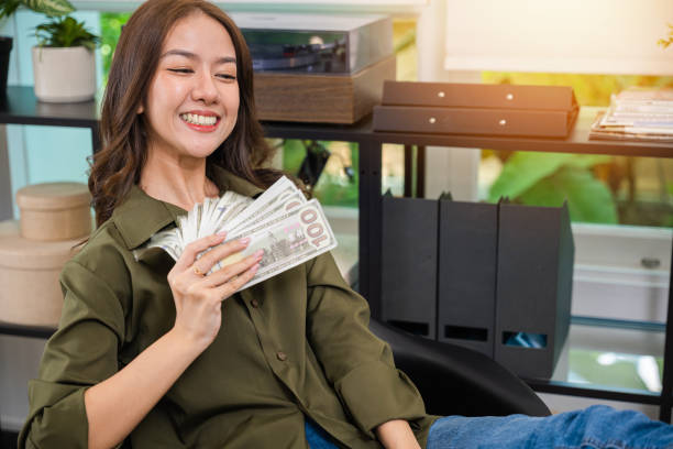 n holding a stack of money and looking towards the horizon, symbolizing the confidence and financial security that investing can bring.